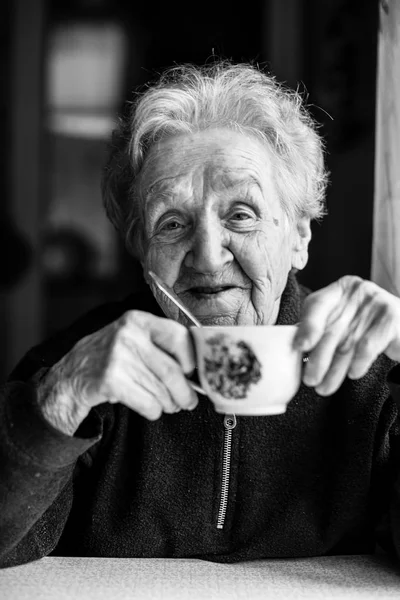 Elderly woman drinking tea. — Stock Photo, Image