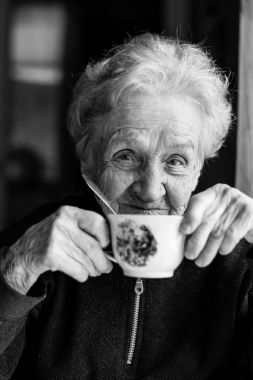 yaşlı kadın bir çay bardağı ile