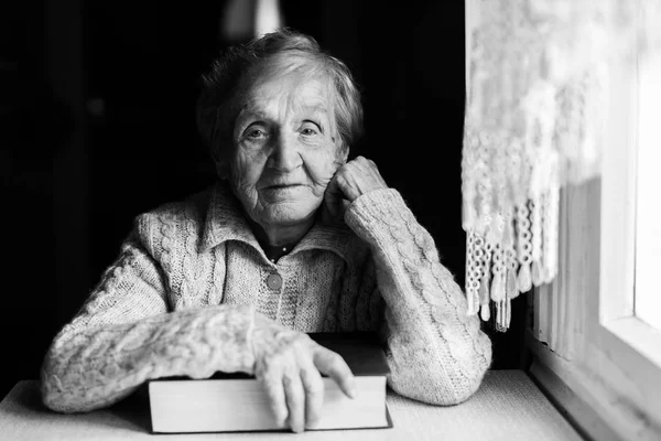 Oudere vrouw met gesloten boek — Stockfoto