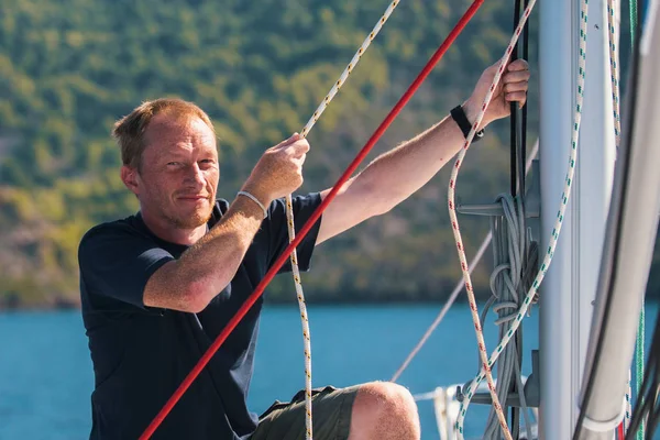Man stramar upp linor på yacht — Stockfoto