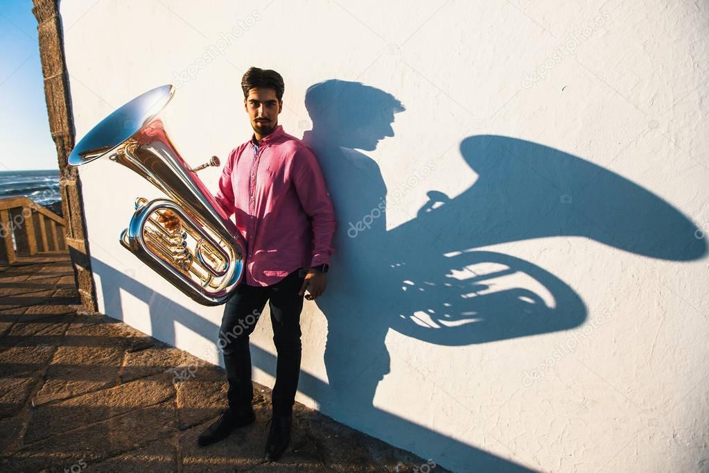 Musician with tuba near the  wall