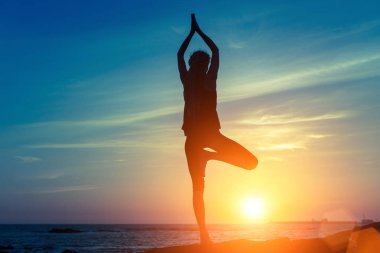 Güzel bir kadın yoga yapıyor.