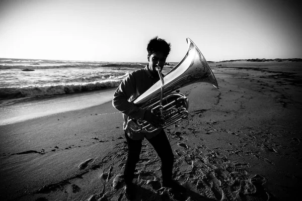 Музыкант играет на тубе в море — стоковое фото