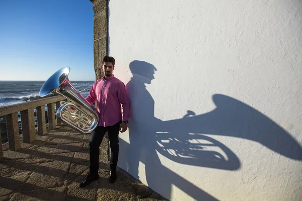 Muzikant met tuba in de buurt van de witte muur — Stockfoto