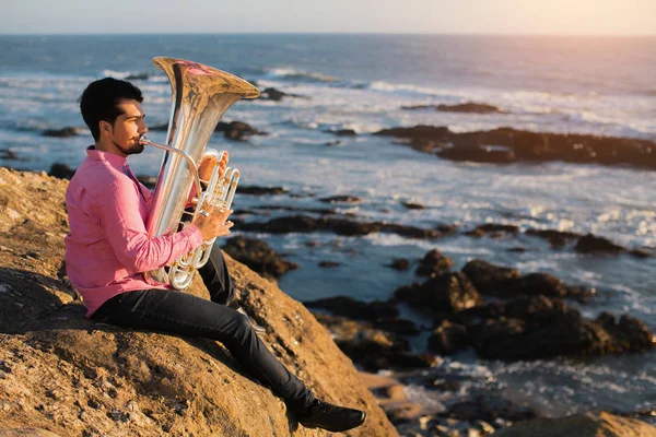 Музыкант играет на музыкальном инструменте туба — стоковое фото