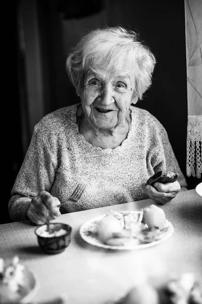 Пожилая женщина ест дома — стоковое фото