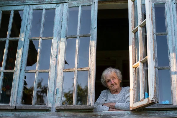 yaşlı kadın penceresinden görünüyor