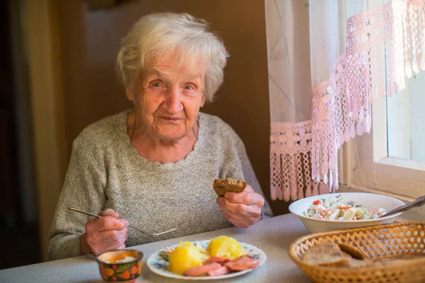 Žena sedí u jídelního stolu — Stock fotografie