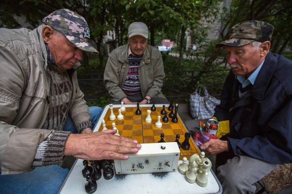 Les retraités jouent aux échecs dans la cour — Photo