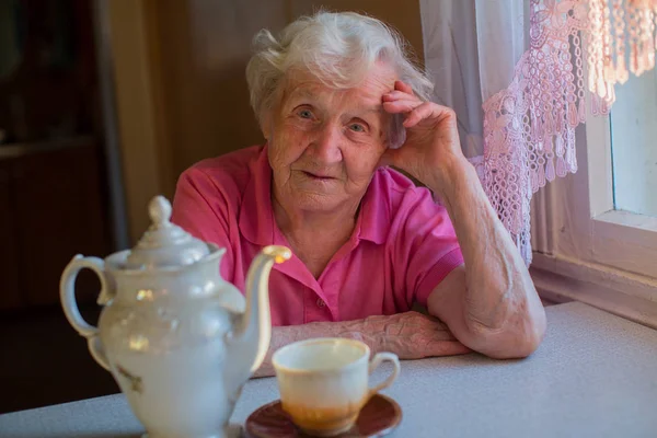 Frau mit Wasserkocher und einer Tasse Tee — Stockfoto