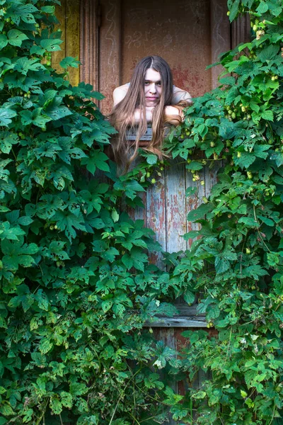 Mulher no alpendre de uma casa de aldeia — Fotografia de Stock