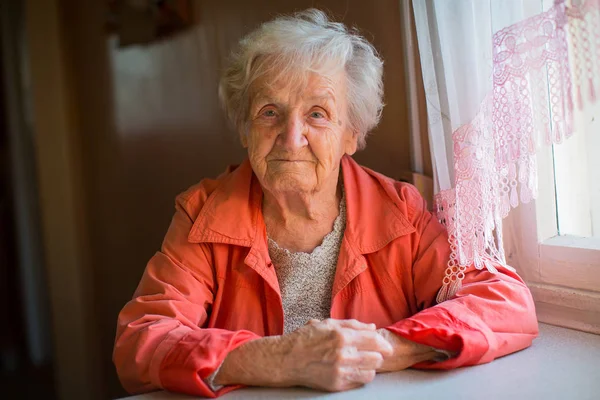 Kırmızı ceketli yaşlı kadın — Stok fotoğraf