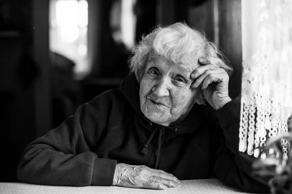 Elderly woman sitting at the table. — Stock Photo, Image