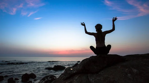 Weibliche Silhouette praktiziert Yoga — Stockfoto