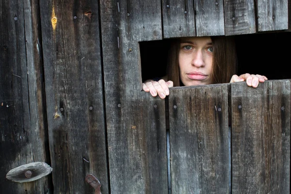 Giovane donna chiusa in un capanno di legno — Foto Stock