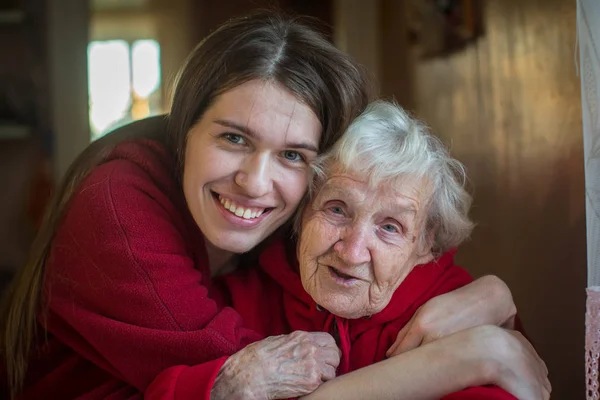 Woman in the hugs of granddaughter. — Stock Photo, Image