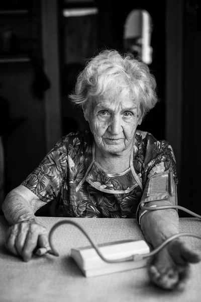 Mujer con una máquina que mide la presión arterial —  Fotos de Stock