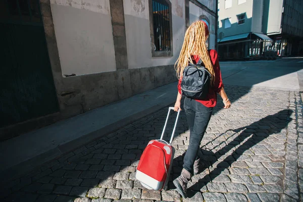 Giovane Donna Sul Marciapiede Con Una Valigia Rossa Vista Posteriore — Foto Stock