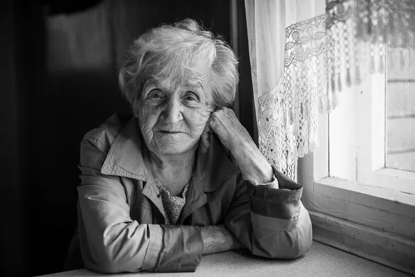 Ältere Frau sitzt im Haus. — Stockfoto