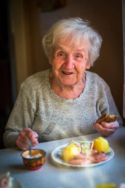 Elderly woman eating lunch — Stock Photo, Image