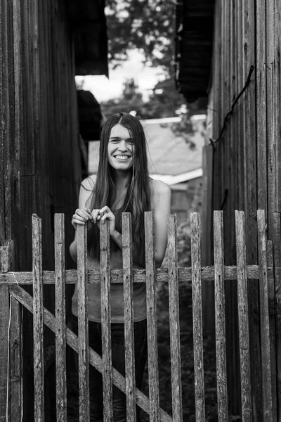 Meisje in de buurt van het houten hek — Stockfoto