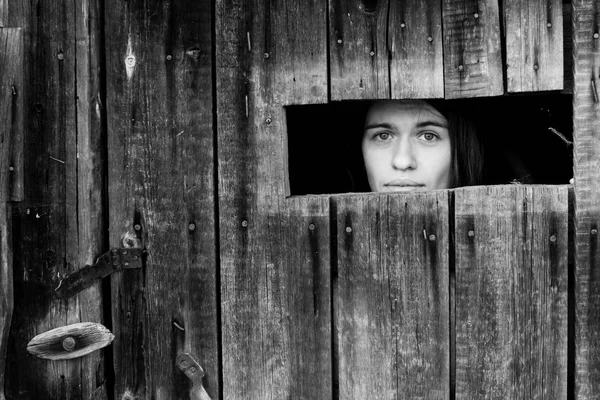Fiatal nő, egy fából készült fészer zárva — Stock Fotó