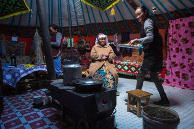 SAGSAI, BAYAN-OLGIY, MONGOLIA - SEP 28, 2017: Kazakh family of hunters with golden eagles inside the mongolian Yurt. In Bayan-Olgii Province is populated mainly by Kazakhs (88,7%)