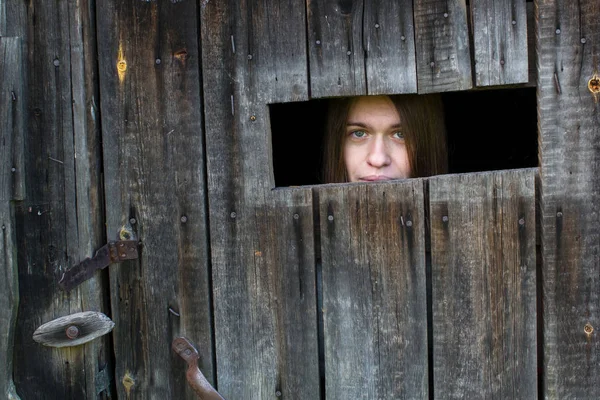 Junge Frau Eingesperrt Einer Holzscheune Aus Dem Aufgeschlitzten Fenster Schauend — Stockfoto