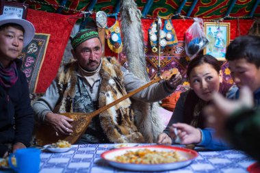 SAGSAI, BAYAN-OLGIY, MONGOLIA - SEP 28, 2017: Kazakh family of hunters with golden eagles inside the mongolian Yurt. In Bayan-Olgii Province is populated mainly by Kazakhs (88,7%)