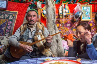 SAGSAI, BAYAN-OLGIY, MONGOLIA - SEP 28, 2017: Kazakh family of hunters with golden eagles inside the mongolian Yurt. In Bayan-Olgii Province is populated mainly by Kazakhs (88,7%)