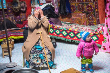 SAGSAI, BAYAN-OLGIY, MONGOLIA - SEP 28, 2017: Kazakh family of hunters with golden eagles inside the mongolian Yurt. In Bayan-Olgii Province is populated mainly by Kazakhs (88,7%)