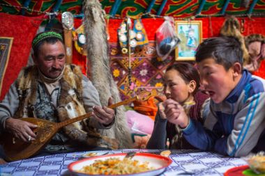 SAGSAI, BAYAN-OLGIY, MONGOLIA - SEP 28, 2017: Kazakh family of hunters with golden eagles inside the mongolian Yurt. In Bayan-Olgii Province is populated mainly by Kazakhs (88,7%)