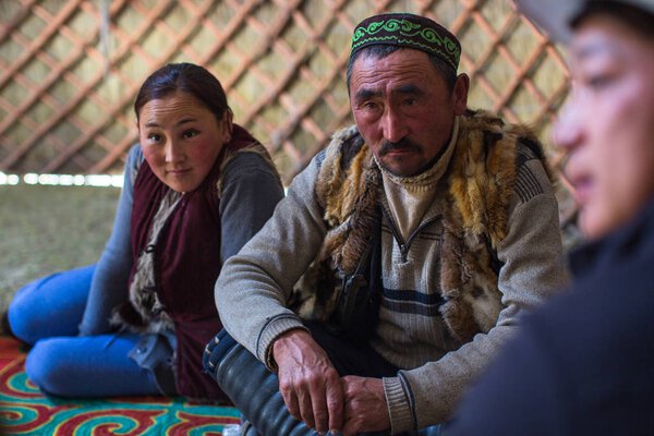 SAGSAI, BAYAN-OLGIY, MONGOLIA - SEP 28, 2017: Kazakh family of hunters with golden eagles inside the mongolian Yurt. In Bayan-Olgii Province is populated mainly by Kazakhs (88,7%)