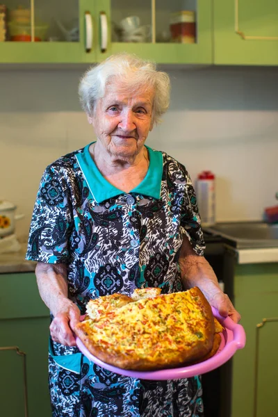 Mulher Idosa Cozinha Com Uma Torta Nas Mãos — Fotografia de Stock