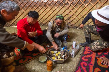 SAGSAI, BAYAN-OLGIY, MONGOLIA - SEP 28, 2017: Kazakh family of hunters with golden eagles inside the mongolian Yurt. In Bayan-Olgii Province is populated mainly by Kazakhs (88,7%)