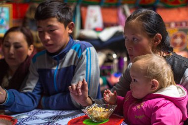 SAGSAI, BAYAN-OLGIY, MONGOLIA - SEP 28, 2017: Kazakh family of hunters with golden eagles inside the mongolian Yurt. In Bayan-Olgii Province is populated mainly by Kazakhs (88,7%)