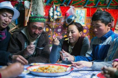 SAGSAI, BAYAN-OLGIY, MONGOLIA - SEP 28, 2017: Kazakh family of hunters with golden eagles inside the mongolian Yurt. In Bayan-Olgii Province is populated mainly by Kazakhs (88,7%)