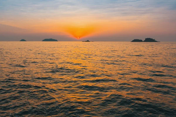 Günbatımı güneş ışığı dalgalar yamalari ile denizde.