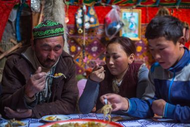 SAGSAI, BAYAN-OLGIY, MONGOLIA - SEP 28, 2017: Kazakh family of hunters with golden eagles inside the mongolian Yurt. In Bayan-Olgii Province is populated mainly by Kazakhs (88,7%)