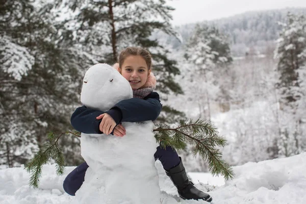 女の子と雪だるま 冬の子供ゲーム — ストック写真