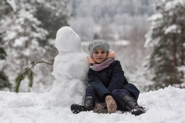 かわいい女の子を Sculpts 雪だるま — ストック写真