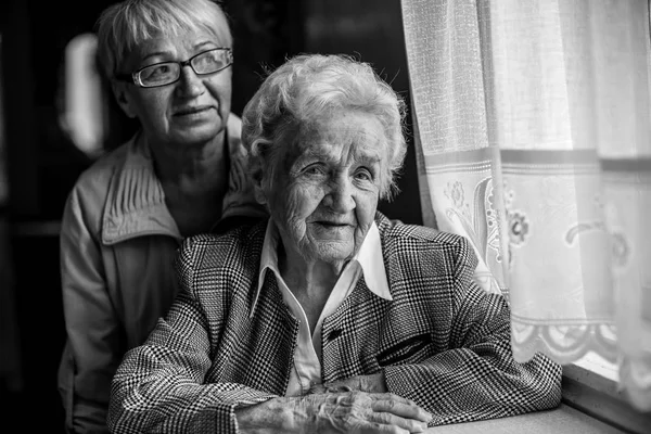 Una Anciana Sentada Mesa Junto Una Hija Adulta Foto Blanco — Foto de Stock