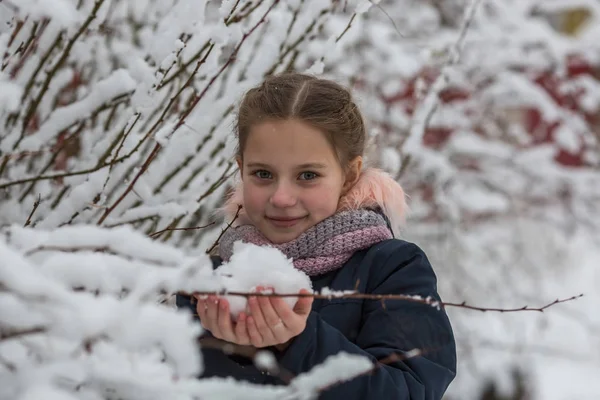 かわいい女の子の手で雪を保持します — ストック写真
