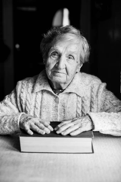 Ältere Frau Mit Geschlossenem Buch Tisch — Stockfoto