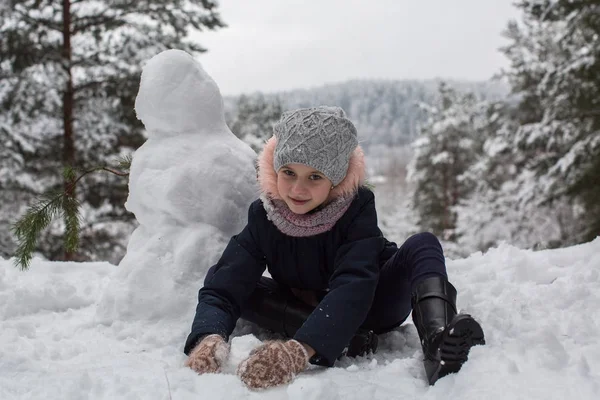 Menina Bonito Esculpe Boneco Neve Inverno Parque Nevado — Fotografia de Stock