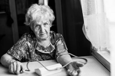 yaşlı kadın arteriyel basınç ölçer. Siyah-beyaz fotoğraf.