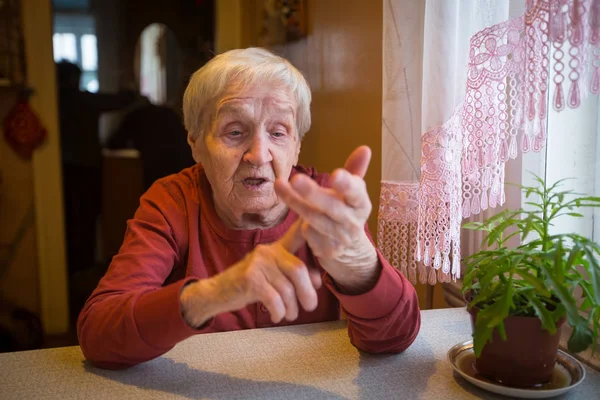 Пожилая Женщина Жестом Сидя Столом — стоковое фото