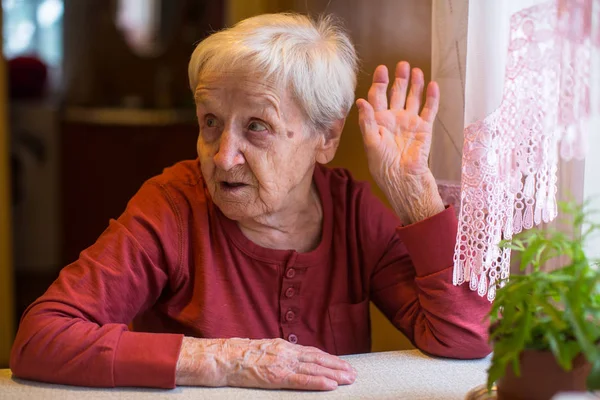 Ηλικιωμένη Γυναίκα Χειρονομώ Ενώ Κάθεται Στο Τραπέζι — Φωτογραφία Αρχείου