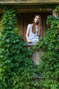 kırsal ev verandada uzun saçlı genç kadın.