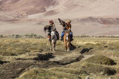 Sagsay, Moğolistan - 28 Eylül 2017: Bayan-Olgii Aymağı dağlarında bir Altın Kartallar ile tavşan kızı avcılık için kazak kartal Hunter (Berkutchi) atı ile öğretir. 